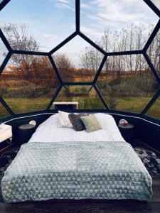 łóżko w pokoju z dużym oknem w obiekcie Kuuselepa klaaskuppel w mieście Tartu