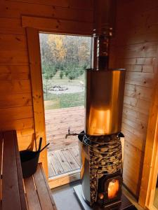 a wood fired stove in a cabin with a window at Kuuselepa klaaskuppel in Tartu