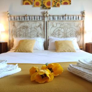 Una cama con dos flores amarillas encima. en La casetta di campagna Alloggio nel Chianti, en Pomino