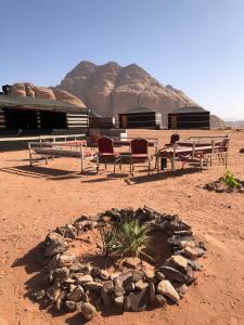 a group of picnic tables and chairs in the desert at Beduin Star Trail Camp in Wadi Rum
