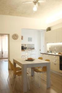 cocina y comedor con mesa blanca y sillas en Casa Pierina, en Santa Marinella