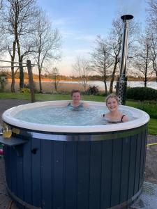 a man and a woman in a hot tub at Willow Lodge in Lisnaskea