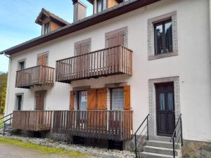 een wit gebouw met houten balkons bij Chez la malou in La Bresse +7 foto's