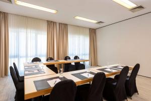 a meeting room with long tables and chairs at Tryp by Wyndham Rosenheim in Rosenheim