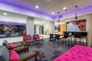 een lobby met stoelen en tafels en een groot scherm bij La Quinta Inn & Suites by Wyndham Augusta Fort Eisenhower in Augusta