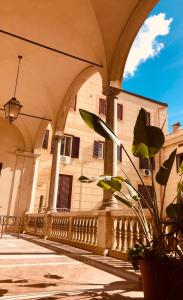 パレルモにあるPalazzo Ventimigliaのアーチと植物が目の前にある建物