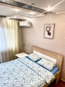 a bedroom with a bed and a picture on the wall at Панорамні апартаменти in Lviv