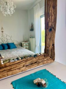 ein Schlafzimmer mit einem Bett mit einem Spiegel und einem blauen Teppich in der Unterkunft Aegean Pearl in Posidi