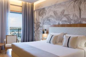 a hotel room with a bed and a balcony at Ramada by Wyndham , Athens Club Attica Riviera in Mati