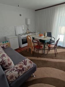 sala de estar con sofá y mesa con sillas en Apartman Bor, en Livno