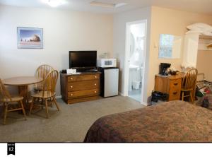 a hotel room with a bed and a table and a television at Ecola Creek Lodge in Cannon Beach