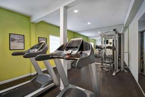 un gimnasio con dos máquinas de correr y paredes verdes en Baymont by Wyndham Houston/Westchase en Houston