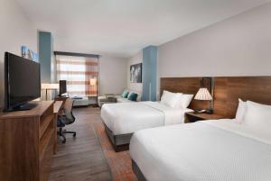 um quarto de hotel com duas camas e uma televisão de ecrã plano em La Quinta Inn & Suites by Wyndham Wisconsin Dells- Lake Delton em Wisconsin Dells