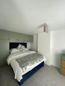 a bedroom with a large bed with a blue headboard at Broughanore Lodge in Dunloy