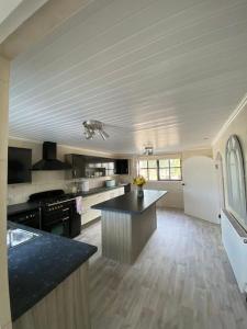 a large kitchen with a large island in the middle at Broughanore Lodge in Dunloy