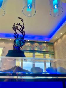 a vase on top of a glass table with blue lights at Aegean Pearl in Possidi