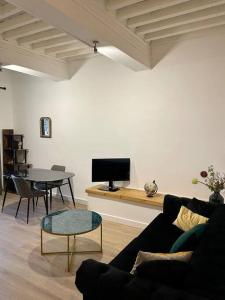 a living room with a couch and a table at Appartement rénové de caractère in Saint-Rémy-de-Provence