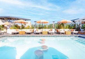 a pool at a hotel with chairs and umbrellas at The Shay, a Destination by Hyatt in Los Angeles