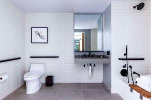 a white bathroom with a toilet and a sink at The Shay, a Destination by Hyatt in Los Angeles