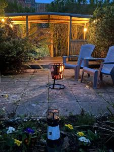 a patio with a table and chairs and a lantern at Turning Tides Holiday Cottage in Great Yarmouth
