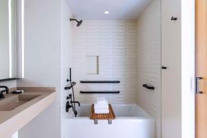 a white bathroom with a tub and a sink at The Shay, a Destination by Hyatt in Los Angeles