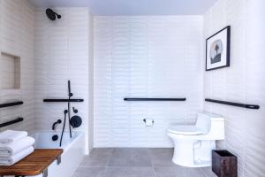 a white bathroom with a toilet and a shower at The Shay, a Destination by Hyatt in Los Angeles