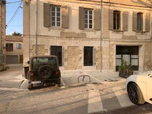 ein Jeep, der vor einem Gebäude parkt in der Unterkunft Appartement rénové de caractère/ parking privé in Saint-Rémy-de-Provence