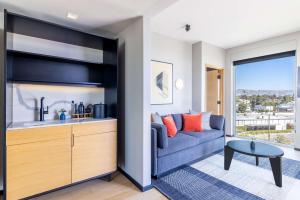 a living room with a blue couch and a table at The Shay, a Destination by Hyatt in Los Angeles