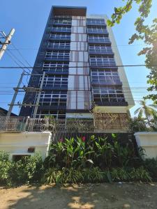 a tall building with some plants in front of it at 23 HOTEL & RESIDENCE in Yangon