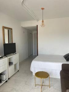 a bedroom with a bed and a tv and a chair at Calle Manuel Mena 4 in Arroyo de la Miel