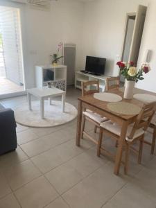 een woonkamer met een houten tafel en stoelen bij Appartement 4 personnes in Narbonne