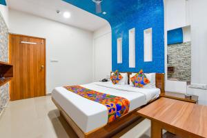 a bedroom with a bed and a wooden table at FabHotel Raj Ratna, Ahmedabad in Ahmedabad
