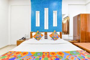 a bedroom with a large bed with a blue wall at FabHotel Raj Ratna, Ahmedabad in Ahmedabad