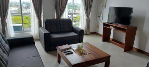 ein Wohnzimmer mit einem Sofa, einem Stuhl und einem TV in der Unterkunft Jays Guest - Rajagiriya Colombo in Rajagiriya