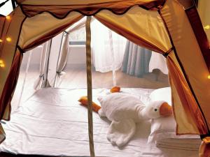 a white stuffed animal laying on a bed at 舟山朱家尖东沙绿城品霞苑酒店式公寓 in Zhoushan