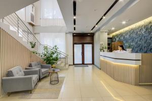 a lobby with a woman standing at a counter at Inter Hotel Bishkek in Bishkek