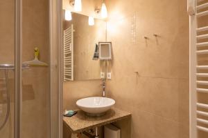 ein Bad mit einem Waschbecken und einem Spiegel in der Unterkunft Syltdomizil Westsuite in Wenningstedt-Braderup