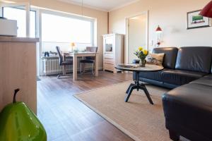 uma sala de estar com um sofá e uma mesa em Syltdomizil Westsuite em Wenningstedt