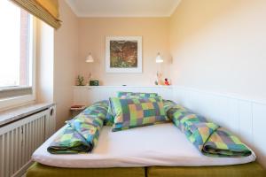 una cama con almohadas en una habitación en Syltdomizil Westsuite, en Wenningstedt