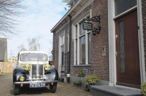 an old car is parked outside of a building at De Parel van Pekel in Nieuwe Pekela