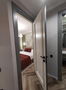 a room with a bed and a door leading to a bedroom at 2-комн на Молдагулова in Shymkent