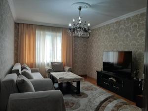 a living room with a couch and a tv at Apartment ЖУЖУНА in Batumi
