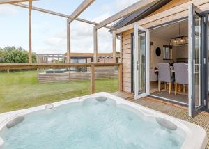 a hot tub on the deck of a house at Cherry Bird Country Park in Newbury