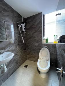 La salle de bains est pourvue de toilettes et d'un lavabo. dans l'établissement The Neighbour KKB - Rooms with shared bathroom, à Kuala Kubu Baharu