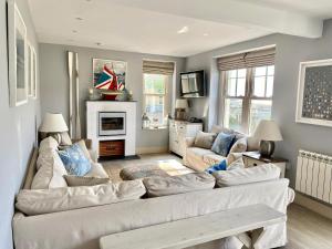 a living room with a white couch and a fireplace at Westray House in Polzeath