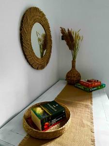 einen Stapel Bücher in einem Korb auf einem Tisch mit einem Spiegel in der Unterkunft Pyrrichos Stone House 