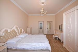 sypialnia z białym łóżkiem i żyrandolem w obiekcie Teryan street, 4 bedrooms Luxury, Unique apartment TT888 w Erywaniu