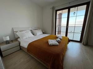 ein Schlafzimmer mit einem Bett mit zwei Handtüchern darauf in der Unterkunft Kalaja Apartment in Prizren