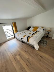 a bedroom with a bed and a wooden floor at Nuits paisibles in Aubière