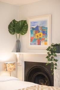 a living room with a fireplace with a plant at Spacious 1BR Victorian Cheltenham flat in Cotswolds Sleeps 4 - FREE Parking in Cheltenham